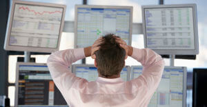 Stock Trader Watching Computer Screens With Hands On Head