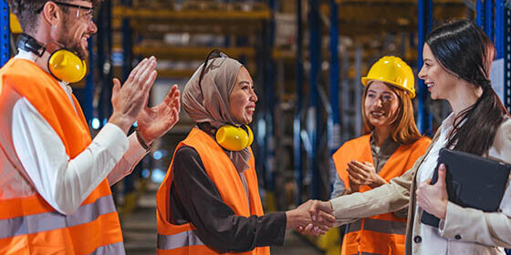 Diverse,Warehouse,Workers,In,High-visibility,Vests,And,Hard,Hats,Shake