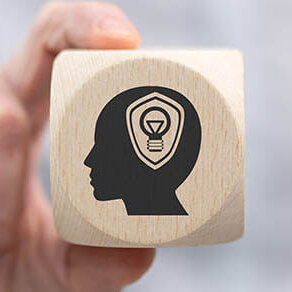 Hand,Holding,A,Wooden,Cube,With,Symbol,Of,Intellectual,Property